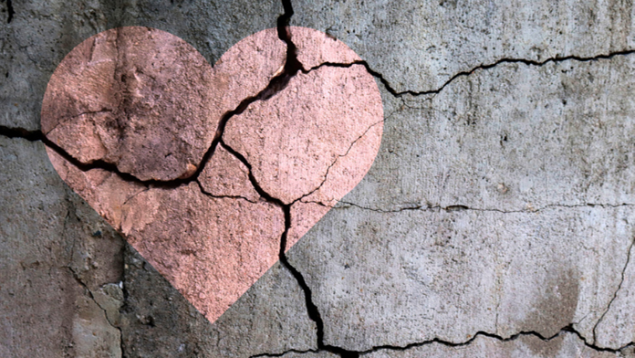 Dried cracked earth with pink heart on it